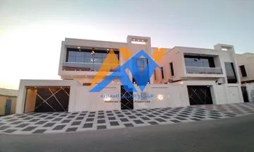 Villa for sale in Ajman, Al Zahia area, 7 master rooms, ground and first, roof, and a concrete car canopy.